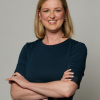 Maureen Glure as she smiles at the camera with her arms crossed